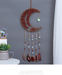 Detail of moon-shaped Tree of Life dream catcher with agate slices and crystals