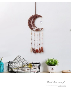 Macro detail of moon-shaped wall hanging with red stones and natural agate slices