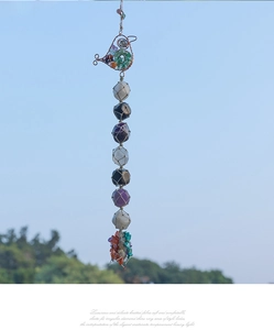 Detail of handmade bird ornament with natural healing stones and woven rope mesh