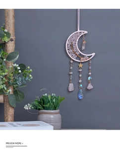 Ciondolo a luna con albero della vita in quarzo rosa e nappe di cristallo su muro