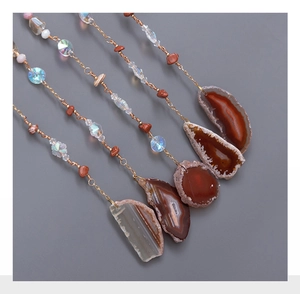 Flat lay of five natural agate slice charms with tree of life crystal beads and gold wire