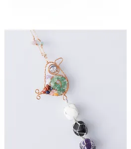 Detailed wire-wrapped bird pendant with green gravel and natural crystal stones