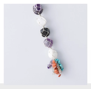 Detail of bohemian handmade crystal hanging ornament with natural stones and woven mesh