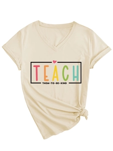 Détail du t-shirt beige à col en V avec slogan 'TEACH THEM TO BE KIND' et ourlet noué