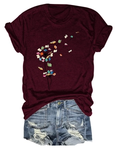 Detail of burgundy T-shirt with dandelion book print paired with distressed denim shorts