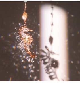 Macro view of handmade wire-wrapped seahorse pendant with faceted crystals and citrine