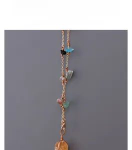 Detailed view of golden chain featuring multi-colored irregular crystal stones