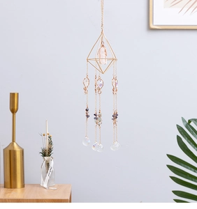 Detail view of crystal suncatcher with pink quartz and metal chains for home decor