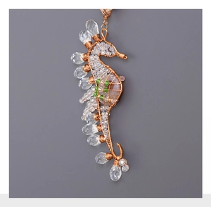 Detailed wire-wrapped seahorse pendant with clear crystals and brown natural stone inlay