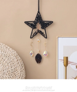 Detail of life tree suncatcher with obsidian stones, crystals and agate slice hanging