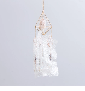 Detail of a geometric metal suncatcher with rose quartz and hanging prism pendants