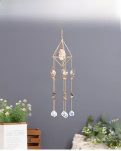 Detail of golden suncatcher with pink quartz crystal and faceted glass prisms for window