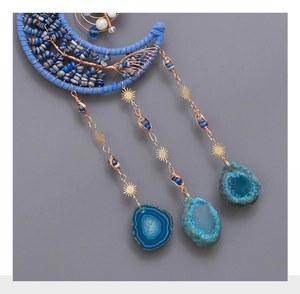 Detail of moon-shaped dreamcatcher with lapis lazuli, agate slices, and wire wrapping