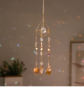 Detail of golden geometric sun catcher with natural agate slices and crystal beads