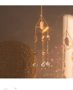 Close-up of golden pyramid suncatcher with crystal prism reflecting rainbow light