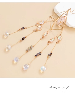 Close-up of geometric suncatcher with golden diamond frame and natural amethyst stones