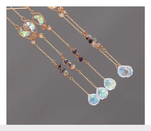 Detailed view of handmade moon fringe jewelry with wire-wrapped purple and blue stones