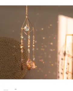 Macro detail of suncatcher featuring clear faceted crystal ball and golden octahedron frame