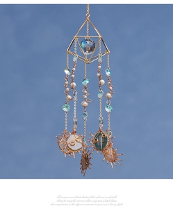 Detail of handmade gold wire-wrapped crystals and natural raw stones on suncatcher