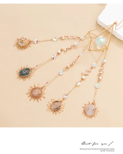 Detailed shot of golden sun pendants with colorful agate stones on a multi-layer suncatcher