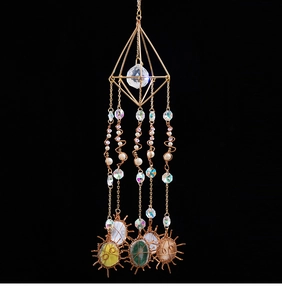 Detailed close-up of handmade crystal suncatcher with natural stones and gold geometric wire