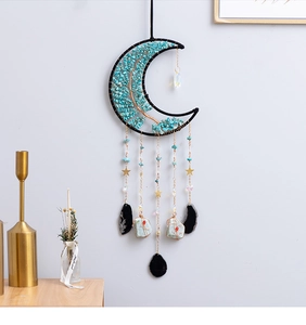 Detail of moon-shaped bohemian wall hanging with turquoise stones and golden star chains