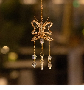 Detailed close-up of golden wire butterfly suncatcher with crystal pendants and beads