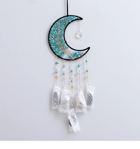 Macro detail of Tree of Life crystal suncatcher with moon frame and turquoise stones