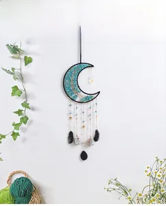 Detail of moon-shaped wall hanging with turquoise stones and star pendant ornaments