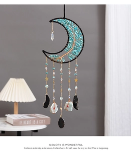 Detail of moon-shaped Tree of Life dreamcatcher with turquoise stones and crystals