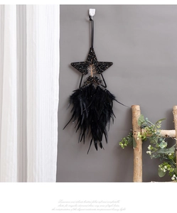 Macro detail of black star dream catcher with bohemian feathers and beaded stone center