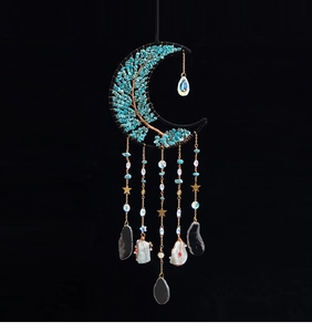 Detail of moon-shaped dream catcher with tree of life turquoise and crystal pendants