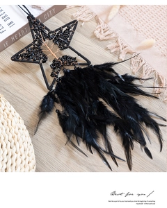Detail of star-shaped dream catcher with black crystals and feathers wall hanging