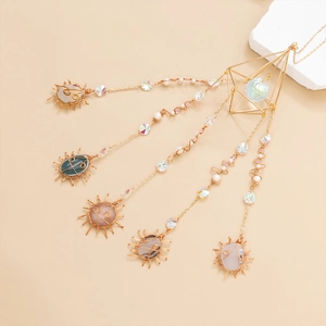 Bohemian gold sun catcher with natural agate slices and crystal ball on beige background