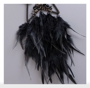 Macro view of black dreamcatcher detailing natural obsidian stones and soft feathers