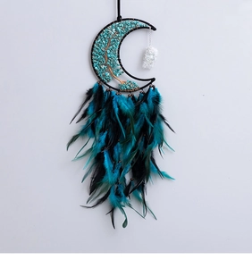 Detail of moon-shaped dreamcatcher wall decor with Tree of Life and blue feathers