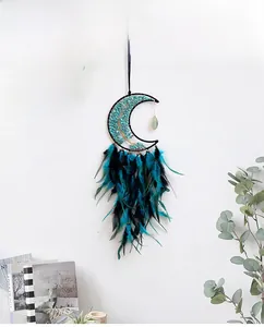 Moon-shaped tree of life dreamcatcher with green crystals and hanging feathers