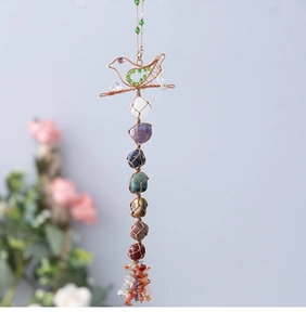 Detailed view of handmade Seven Chakra crystal bird hanging with colorful raw gemstones