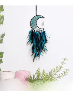 Detail of bohemian crescent moon dreamcatcher with turquoise stones and blue feathers