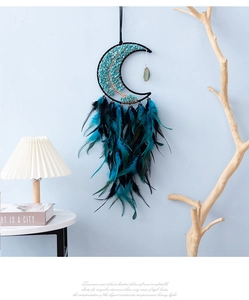 Detail of bohemian crescent moon dream catcher with turquoise stones and dark feathers