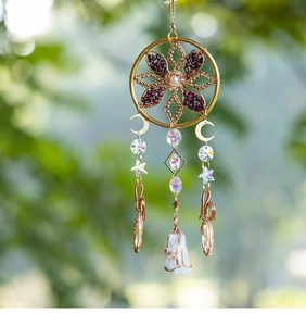 Close-up of bohemian sun catcher with gold ring and raw white crystal stone pendant