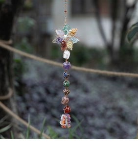Detail of handmade chakra crystal wall decor with woven wire lotus and raw gemstones