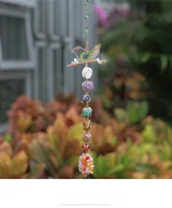 Macro view of hand-woven 7 chakra healing crystals with a wire-wrapped bird-shaped frame