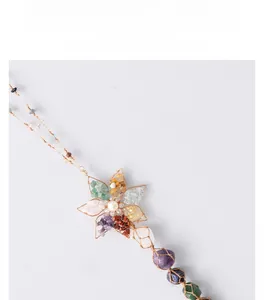 Detail of handmade wire wrapped lotus dreamcatcher with colorful natural raw crystal stones