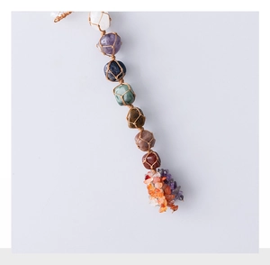 Detailed view of hand-woven Seven Chakra healing crystals hanging with polished stones
