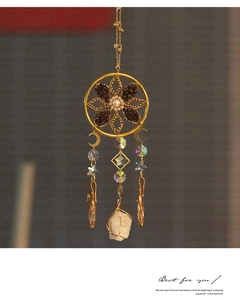 Detail of dreamcatcher wall hanging with crescent moon and raw crystal ornaments