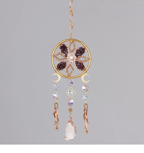 Detail of handmade suncatcher with wire-wrapped white crystal and moon star charms