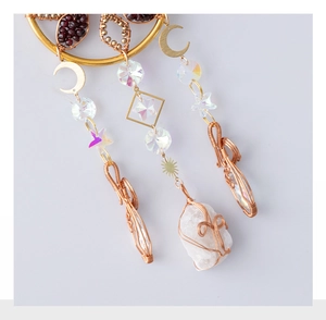 Detail of handmade suncatcher with smoky quartz, crescent moon charms and wire-wrapped stones