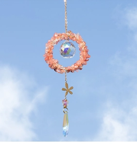 Detailed sun catcher with pink crystal chips and faceted glass teardrop against blue sky