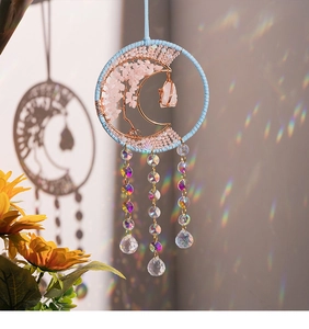 Macro shot of suncatcher detailing pink quartz tree of life and crystal teardrops